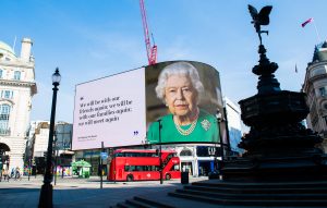 LONDON, ENGLAND - APRIL 10: An image of Queen Elizabeth II and quotes from her broadcast to the nation in relation to the coronavirus epidemic are displayed on screens in Piccadilly Circus on April 10, 2020 in London, England. (Photo by Samir Hussein/WireImage)
